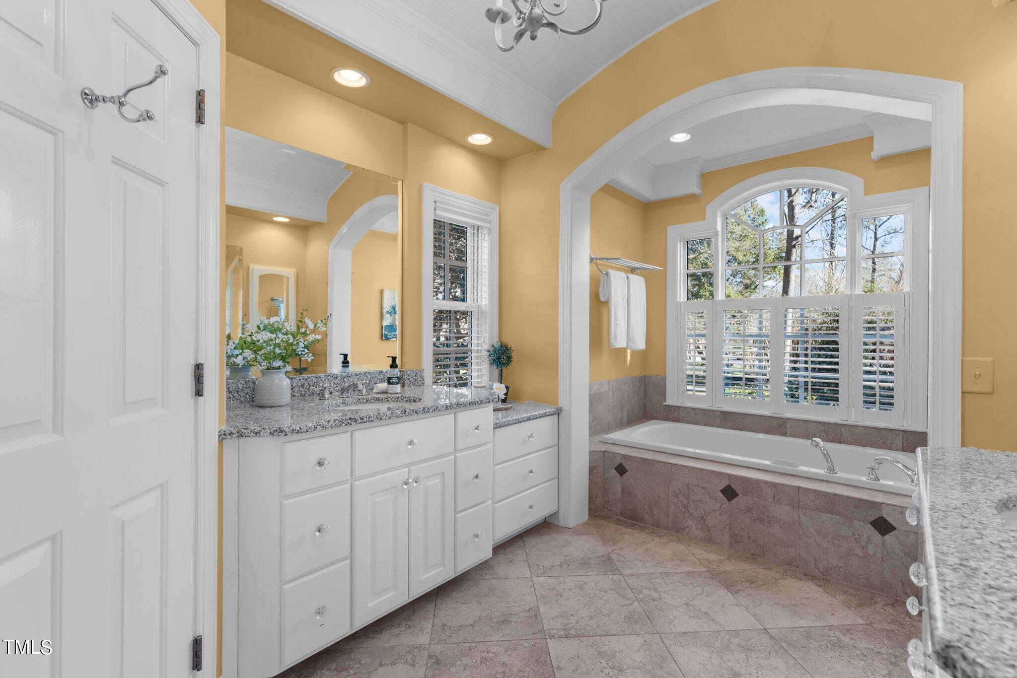 8 Surrey Lane Durham, NC 27707 - Photo 13 of 50 a bathroom with a granite countertop double vanity sink a mirror and a bathtub