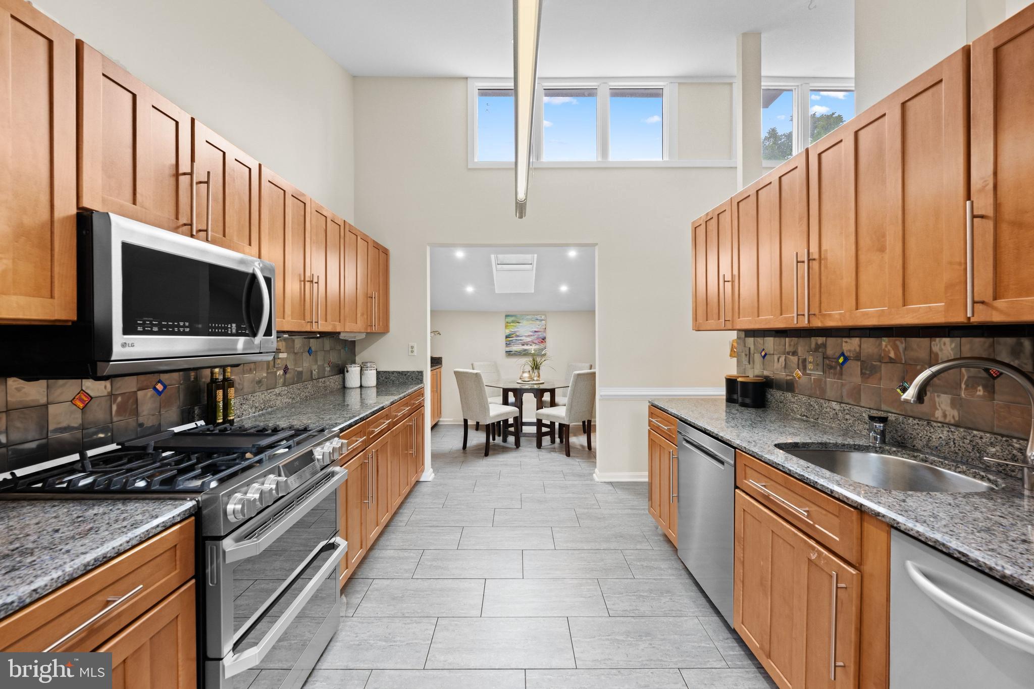 3529 Yuma Street Northwest Washington, DC 20008 - Photo 18 of 46 a kitchen with stainless steel appliances granite countertop a sink a stove top oven a refrigerator cabinets and a dining table
