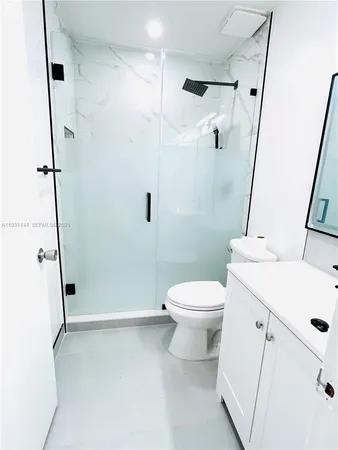 a white toilet sitting next to a bathroom sink and a shower