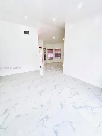 a view of a kitchen with kitchen island a sink wooden floor and entryway