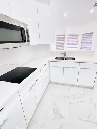 a kitchen with granite countertop a sink a stove and cabinets