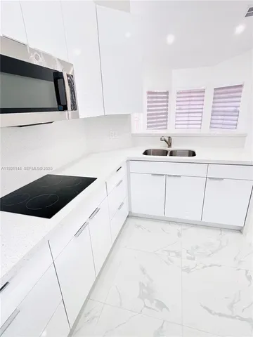 a kitchen with granite countertop a sink a stove and cabinets