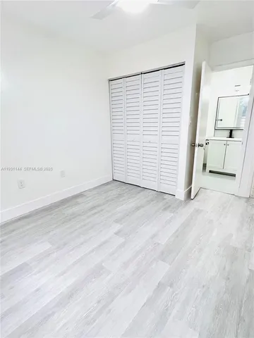 an empty room with wooden floor and white walls