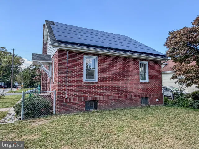 a red brick house with large windows and a yard