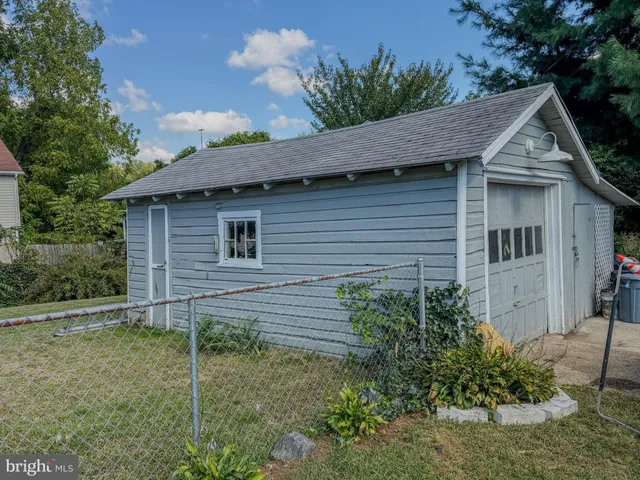 a view of a house with a yard plants and large tree