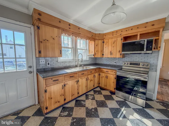 a large kitchen with stainless steel appliances granite countertop a stove top oven a sink and dishwasher