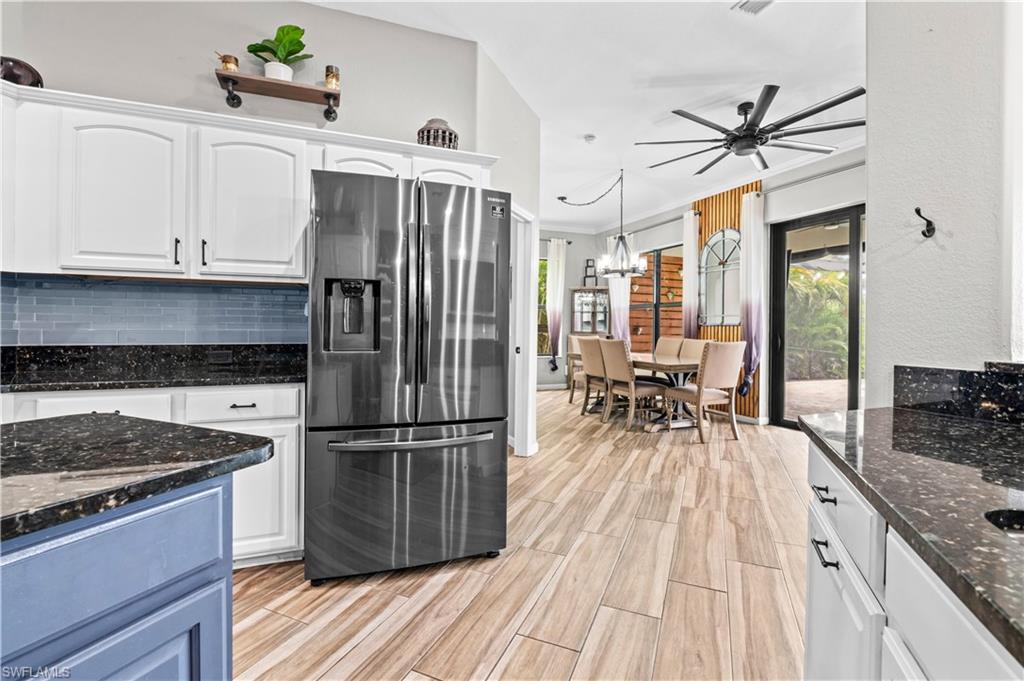 2123 Old Burnt Store Road North Cape Coral, FL 33993 - Photo 20 of 40 a kitchen with granite countertop a refrigerator a stove a sink and white cabinets with wooden floor