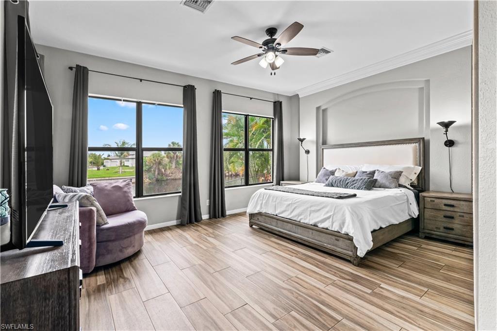 2123 Old Burnt Store Road North Cape Coral, FL 33993 - Photo 23 of 40 a spacious bedroom with a bed couch and a large window