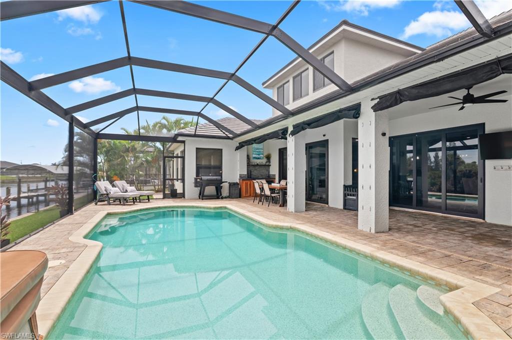 2123 Old Burnt Store Road North Cape Coral, FL 33993 - Photo 32 of 40 a view of a patio with table and chairs under an umbrella