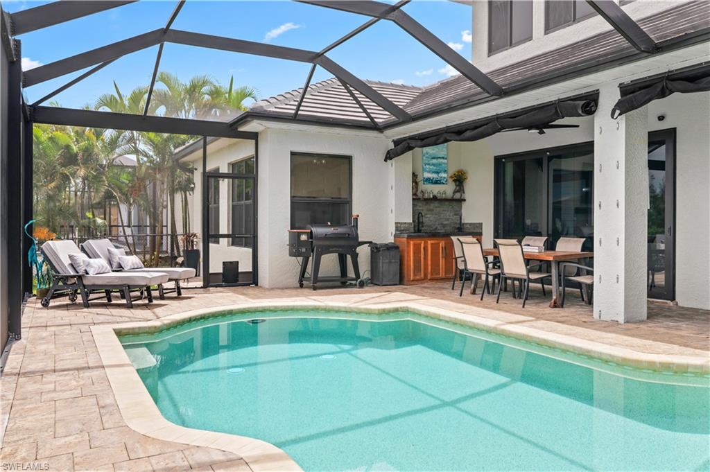 2123 Old Burnt Store Road North Cape Coral, FL 33993 - Photo 33 of 40 a view of a patio with dining table and chairs under an umbrella