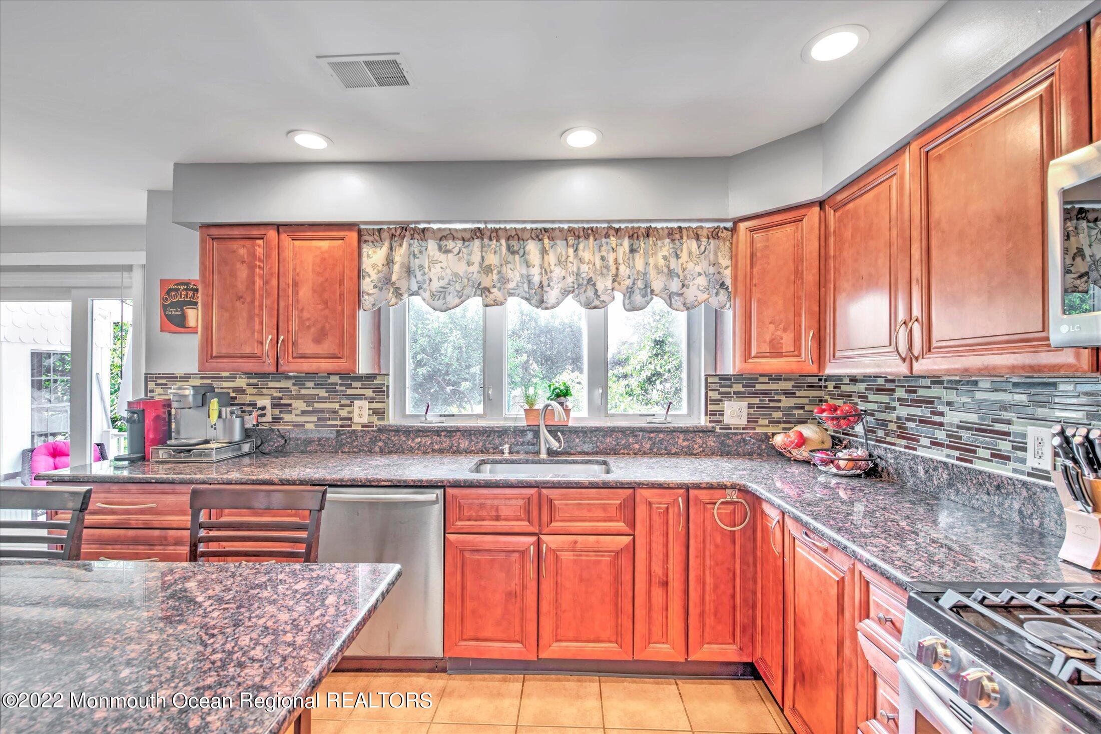 10 MacIntosh Court Jackson, NJ 08527 - Photo 25 of 49 a kitchen with stainless steel appliances granite countertop sink window and cabinets