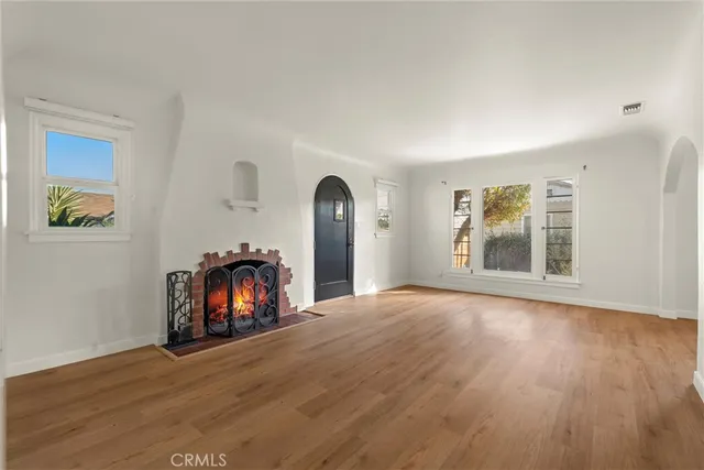 a view of empty room with wooden floor and fireplace