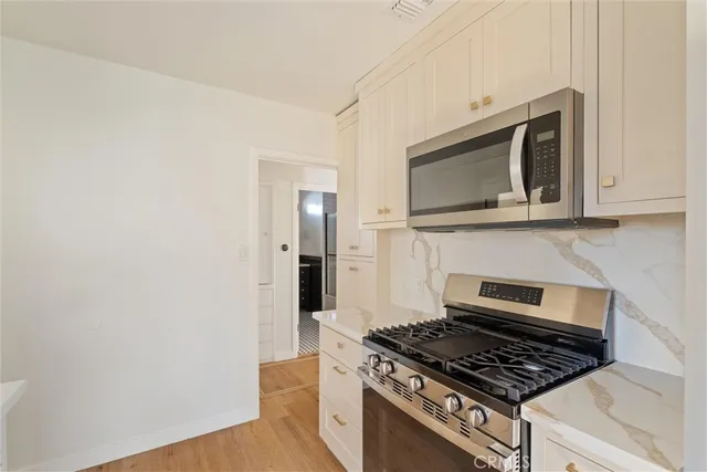 a kitchen with granite countertop cabinets and steel stove top oven