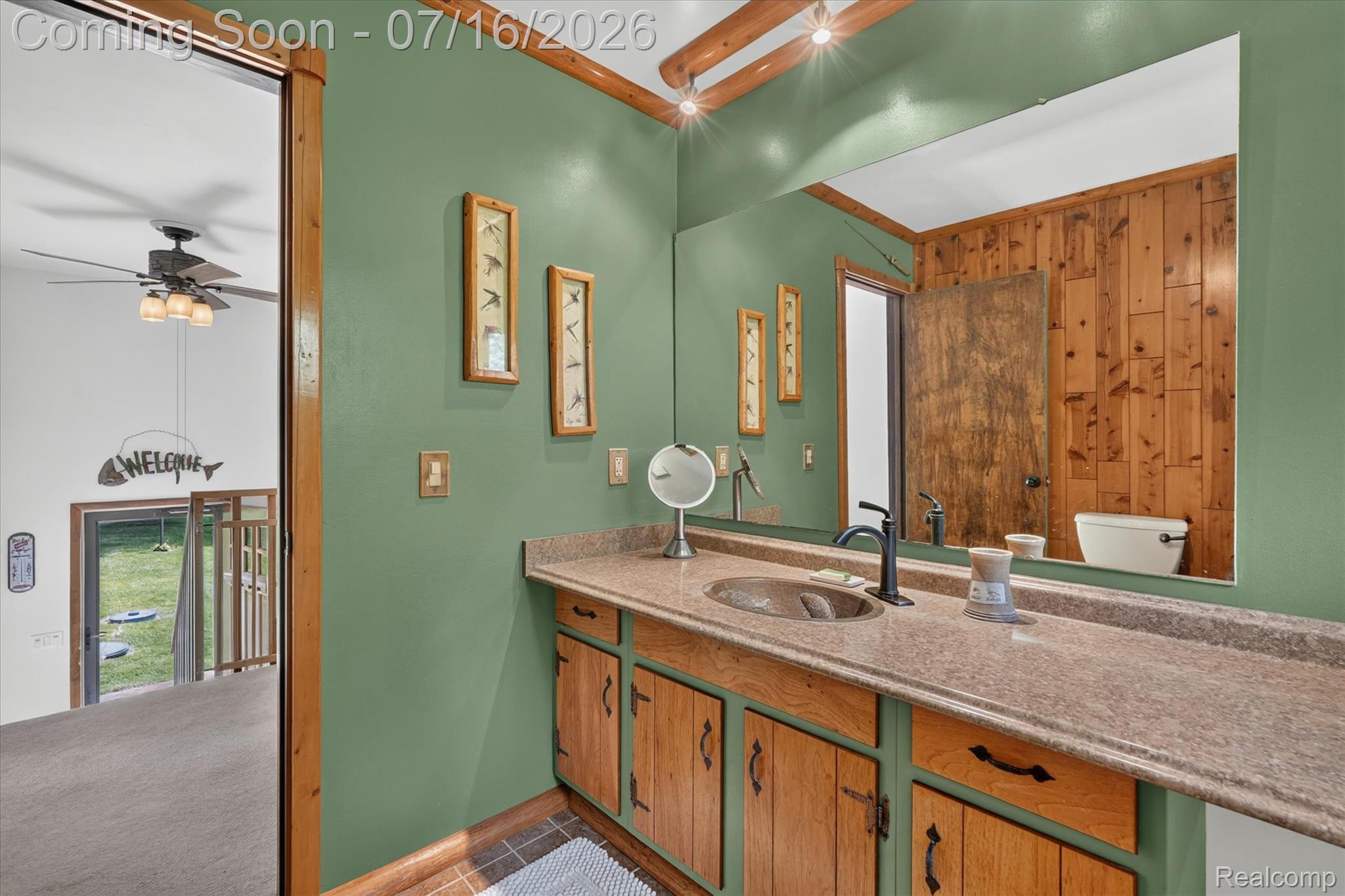11210 Linden Road Linden, MI 48451 - Photo 18 of 61 Bathroom vanity with a countertop sink and matte black faucet, set against green walls