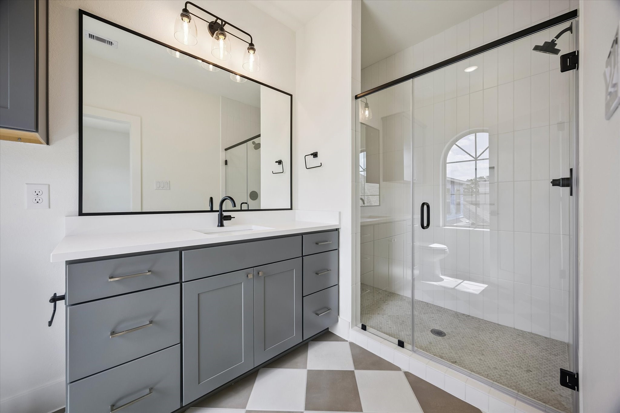 5329 Dora Street Houston, TX 77005 - Photo 30 of 43 One of the secondary bathrooms with a beautiful floor-to-ceiling tiled glass-enclosed shower and trendy checkered tiled flooring