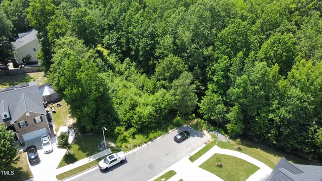 an aerial view of a backyard with swimming pool and trees