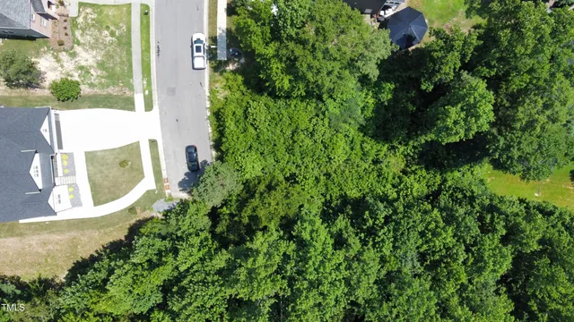 an aerial view of residential house with outdoor space and trees all around