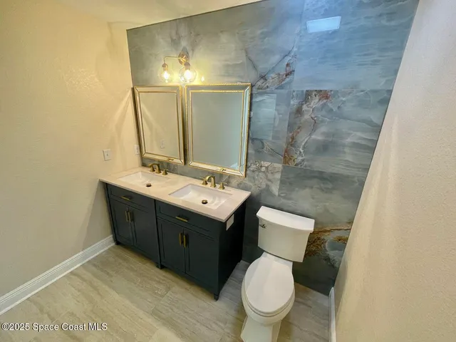 a bathroom with a sink vanity mirror and toilet