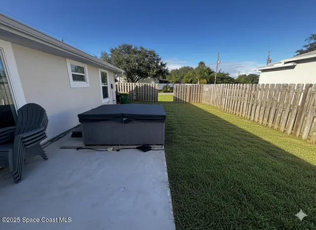 a backyard of a house with table and chairs