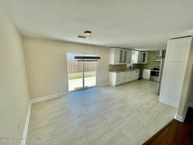 a view of a kitchen with refrigerator and cabinet