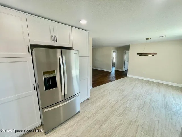 a view of a refrigerator in kitchen and cabinetry