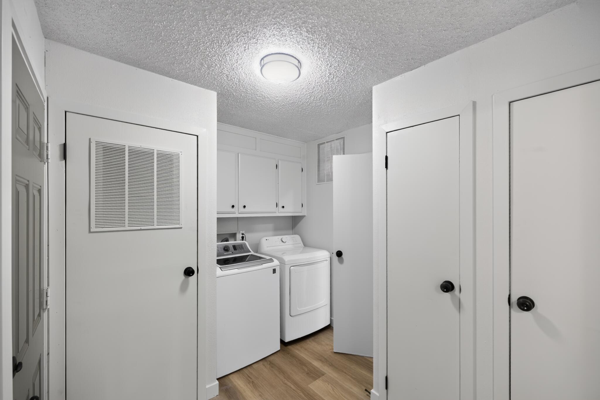 15181 Van Buren Boulevard, Unit 102 Riverside, CA 92504 - Photo 26 of 29 a view of a kitchen with white cabinets and wooden floor