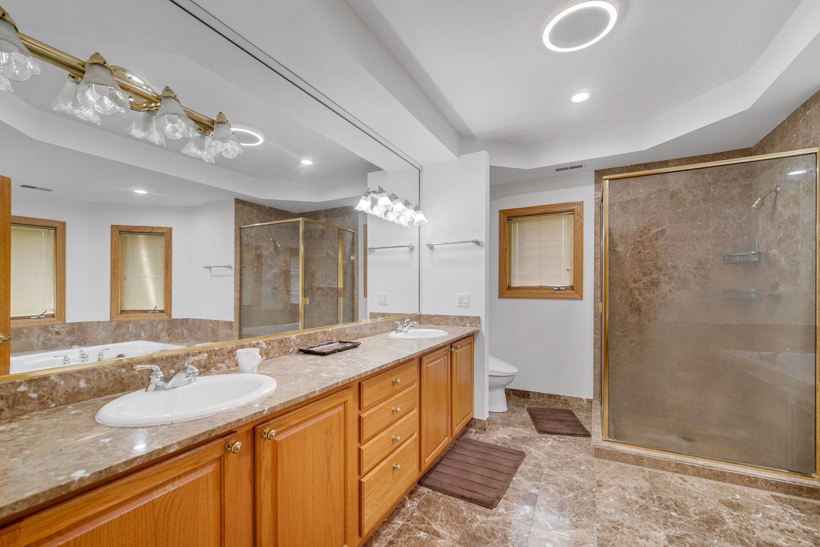 9131 Delphia Street Des Plaines, IL 60016 - Photo 10 of 14 a spacious bathroom with a granite countertop double vanity sink a mirror and a shower