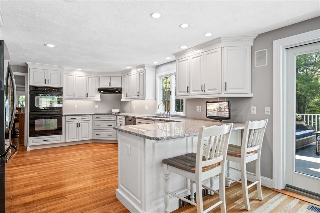 20 Stagecoach Road Topsfield, MA 01983 - Photo 16 of 42 a kitchen with stainless steel appliances granite countertop a stove top oven a sink dishwasher and a refrigerator with wooden floor