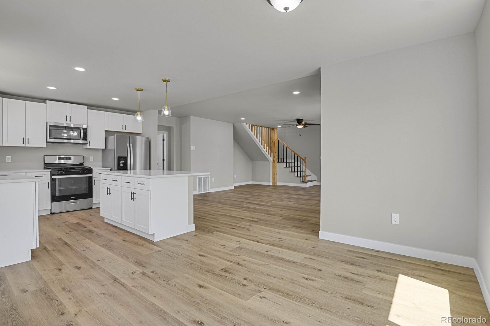 407 Hover Street Longmont, CO 80503 - Photo 12 of 39 a view of kitchen with kitchen island stainless steel appliances wooden cabinets and wooden floor