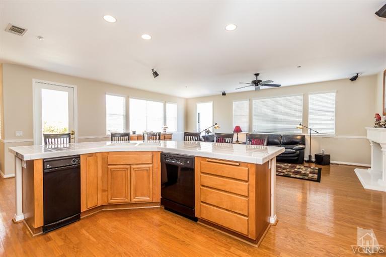 9898 Rhone Street Ventura, CA 93004 - Photo 15 of 44 a large kitchen with stainless steel appliances granite countertop a stove top oven a sink dishwasher and white cabinets with wooden floor