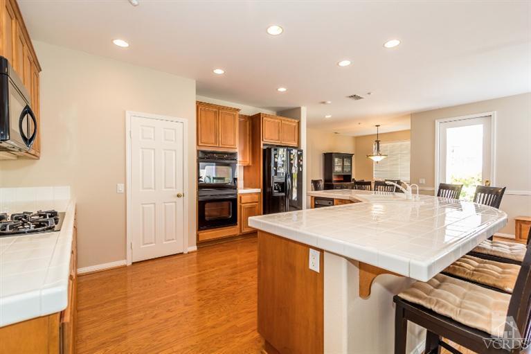 9898 Rhone Street Ventura, CA 93004 - Photo 16 of 44 a large kitchen with kitchen island a sink appliances and a counter top space