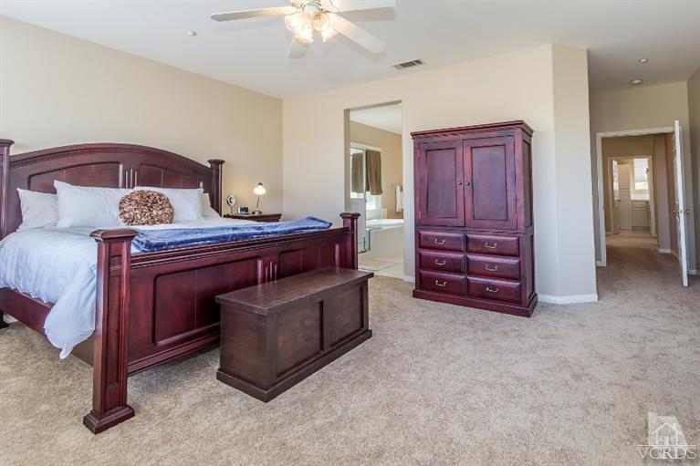 9898 Rhone Street Ventura, CA 93004 - Photo 23 of 44 a spacious bedroom with a bed and a chandelier