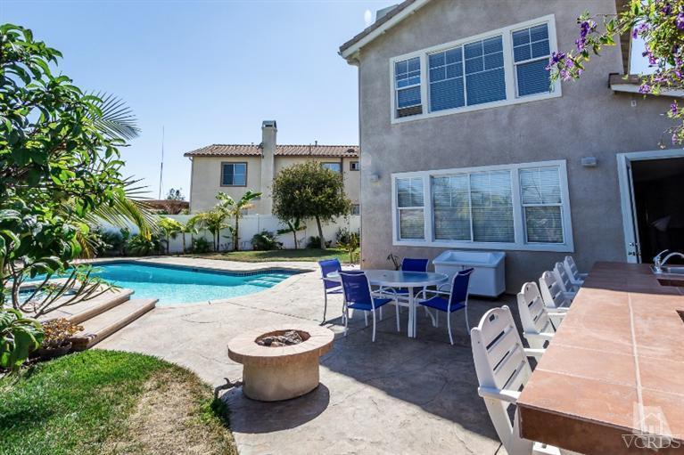 9898 Rhone Street Ventura, CA 93004 - Photo 38 of 44 a view of a patio with table and chairs potted plants and a large tree