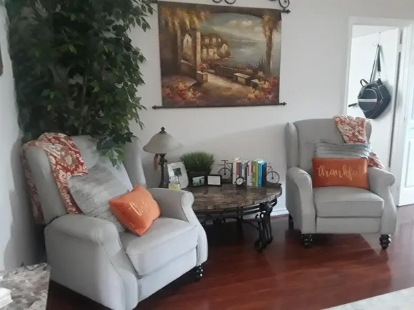 a living room with furniture and a painting on the wall