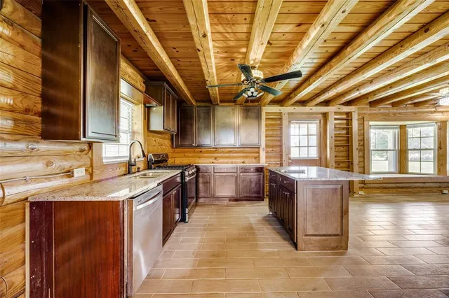 a large kitchen with stainless steel appliances granite countertop a sink and counter space