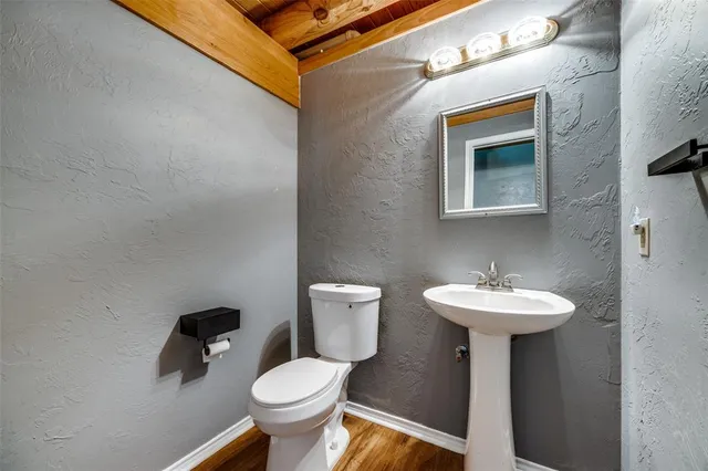a bathroom with a sink toilet and a mirror