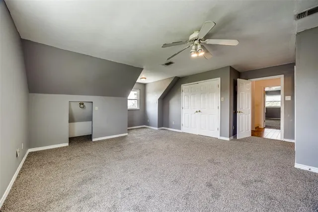 a view of a big room with a chandelier fan and windows