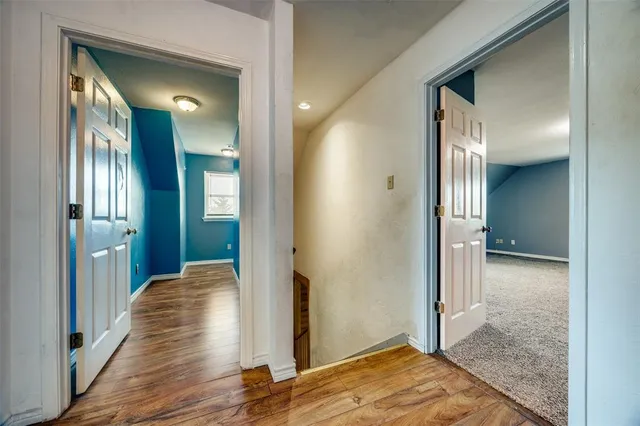 a view of a hallway with wooden floor and staircase