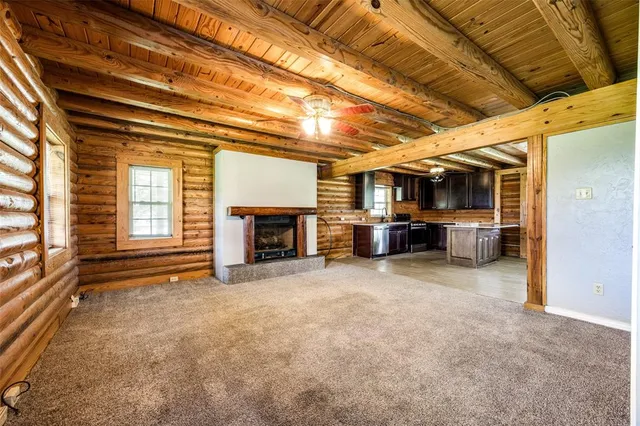 a view of an empty room with a fireplace and a window
