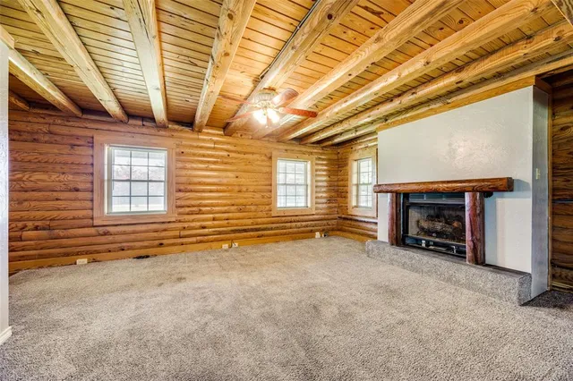 a view of an empty room with a fireplace and a window