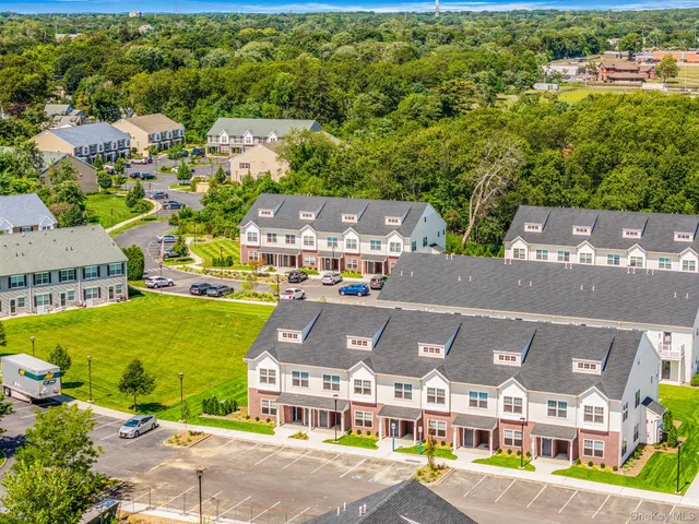 an aerial view of residential houses with outdoor space and parking