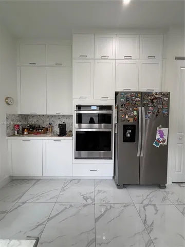 a kitchen with cabinets and steel appliances