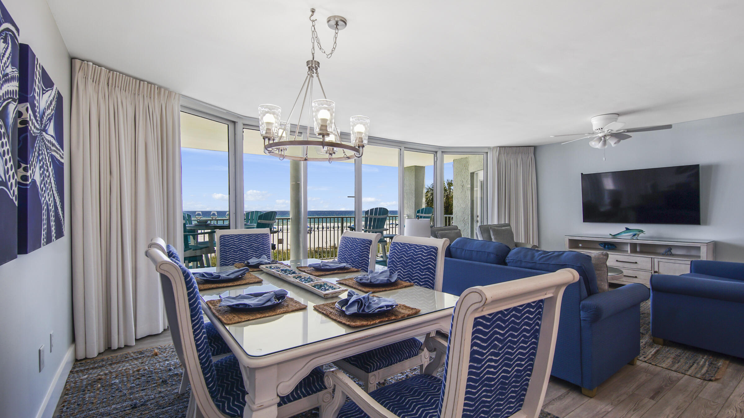 10509 Front Beach Road, Unit 100 Panama City Beach, FL 32408 - Photo 1 of 52 a living room with furniture a flat screen tv and a large window