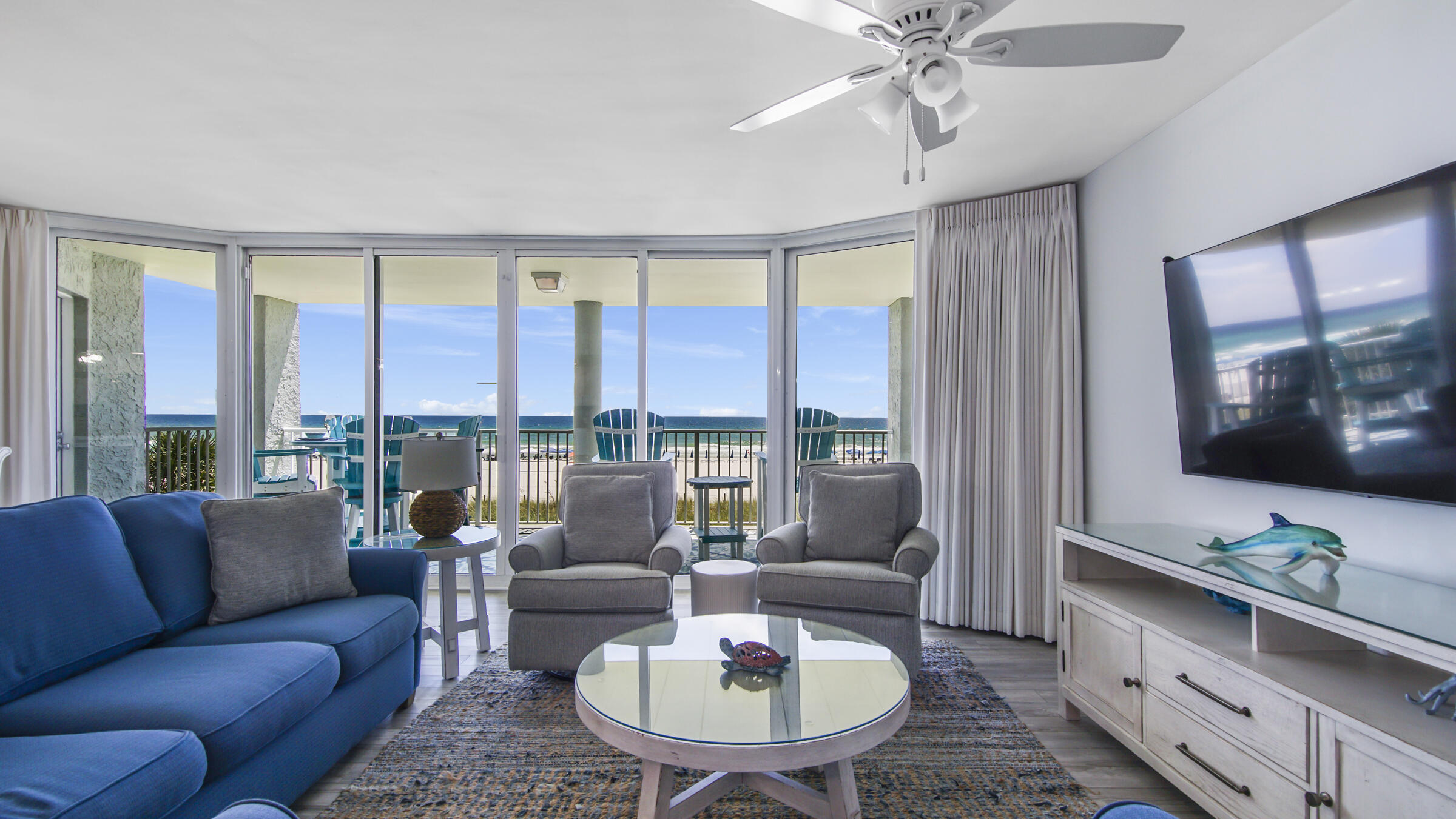 10509 Front Beach Road, Unit 100 Panama City Beach, FL 32408 - Photo 12 of 52 a living room with furniture and a flat screen tv