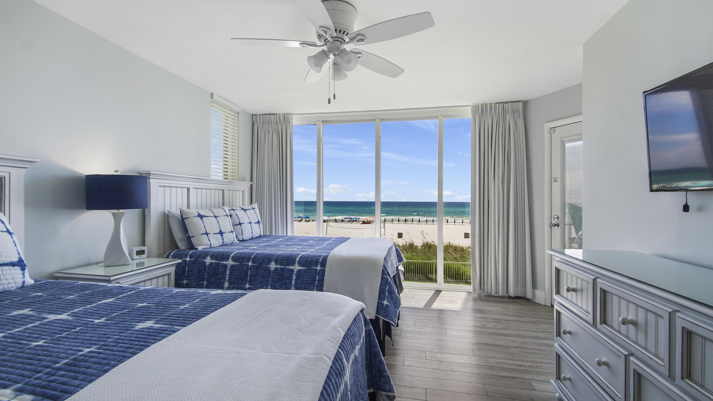 10509 Front Beach Road, Unit 100 Panama City Beach, FL 32408 - Photo 19 of 52 a living room with furniture a flat screen tv and a floor to ceiling window