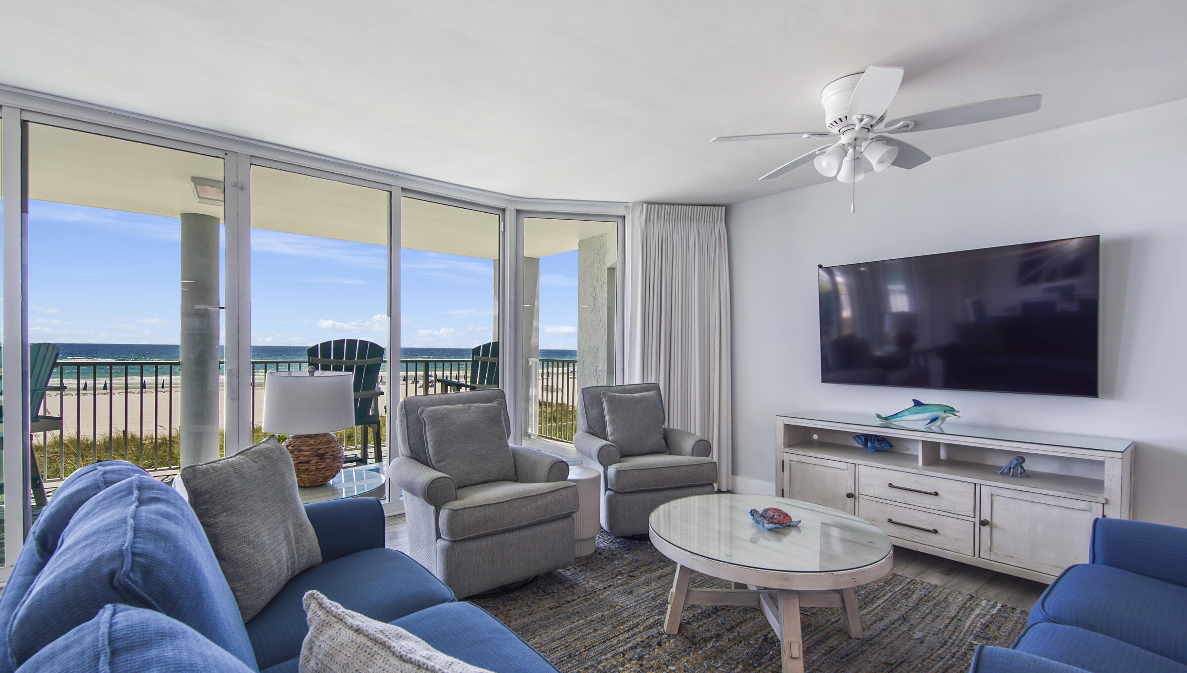 10509 Front Beach Road, Unit 100 Panama City Beach, FL 32408 - Photo 27 of 52 a living room with furniture a flat screen tv and a large window