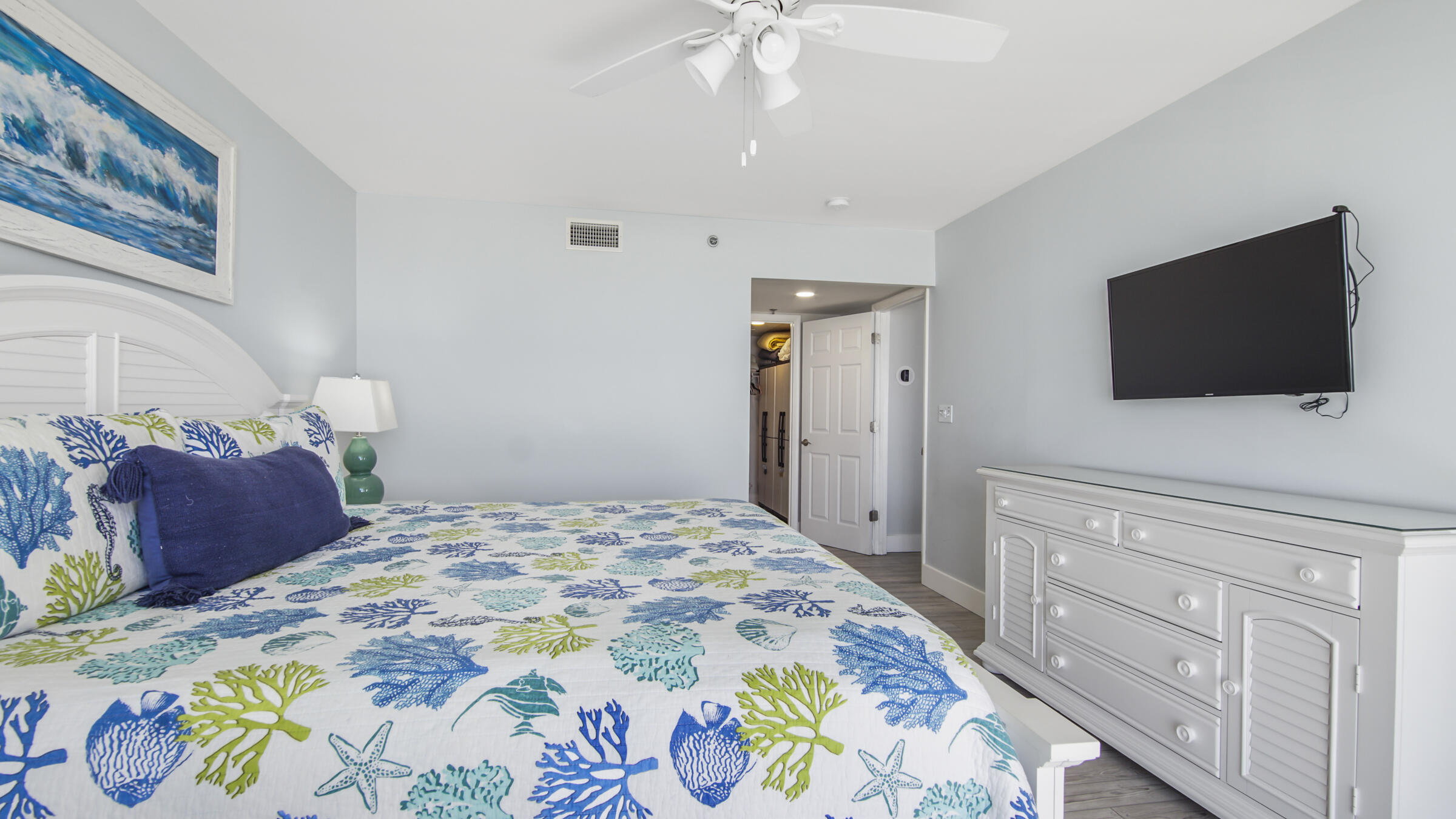 10509 Front Beach Road, Unit 100 Panama City Beach, FL 32408 - Photo 32 of 52 a bedroom with a bed and a flat screen tv in it