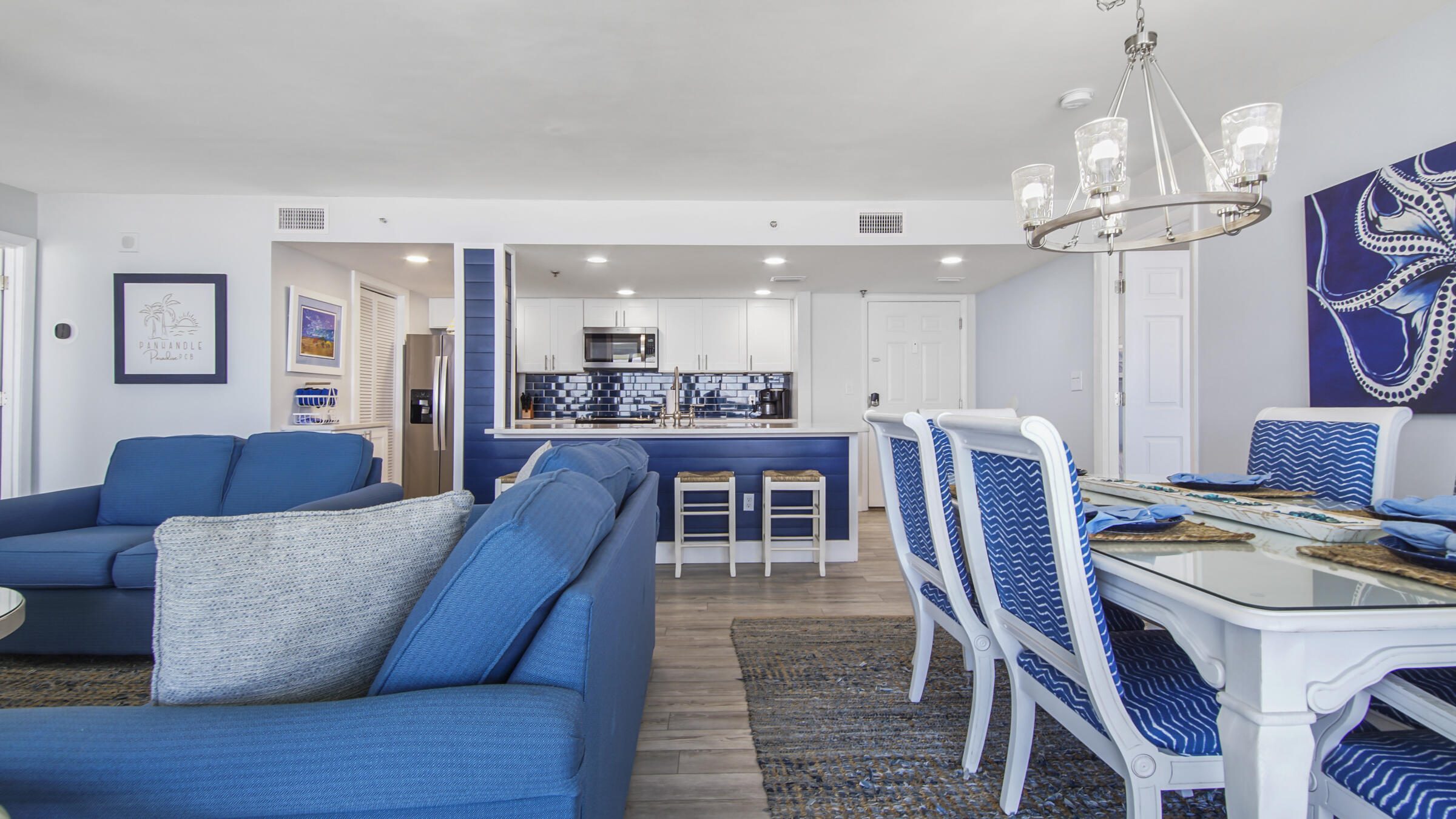 10509 Front Beach Road, Unit 100 Panama City Beach, FL 32408 - Photo 37 of 52 a living room with stainless steel appliances kitchen island granite countertop furniture and a chandelier