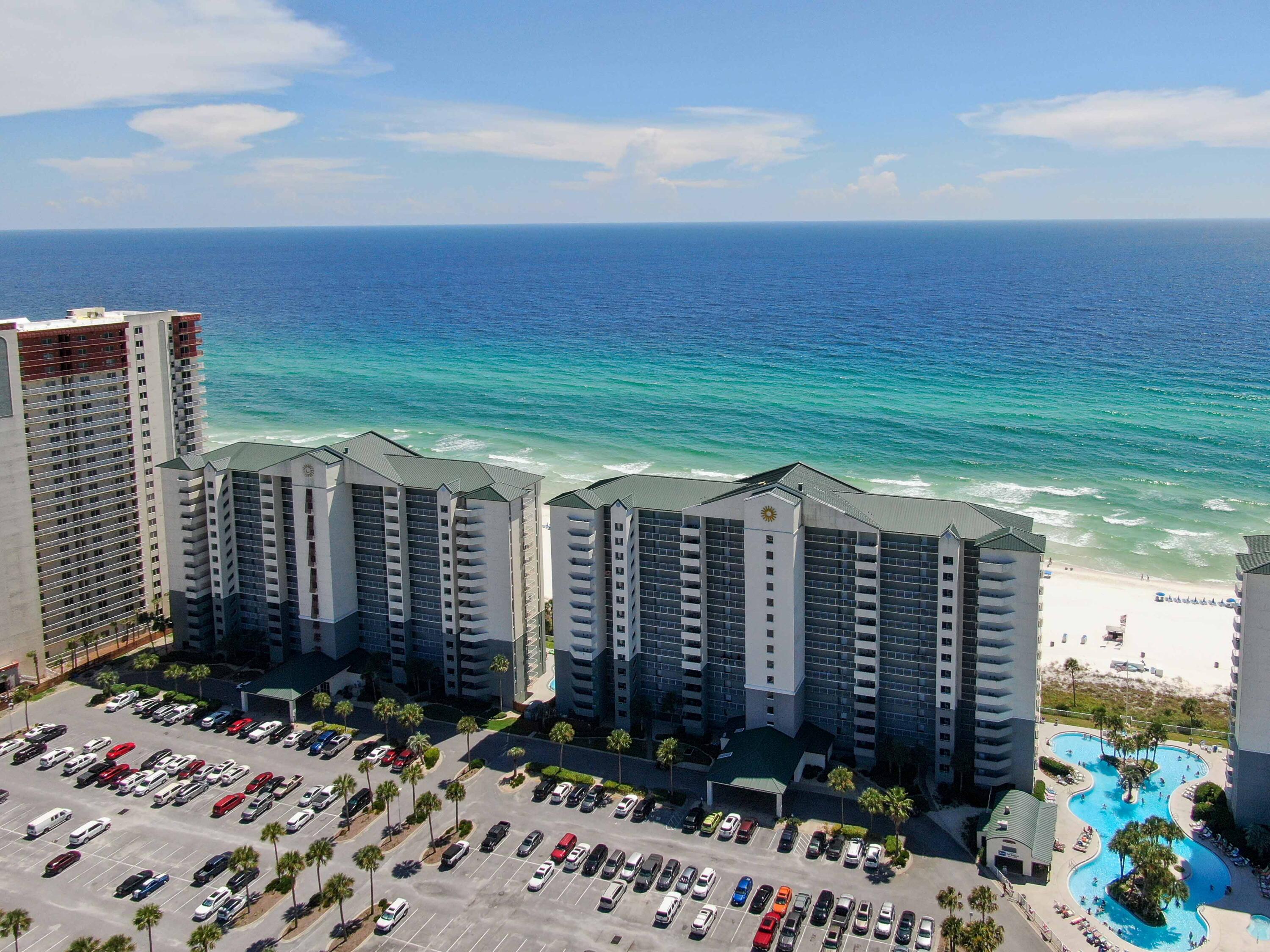 10509 Front Beach Road, Unit 100 Panama City Beach, FL 32408 - Photo 50 of 52 a view of a balcony with chairs potted plants and floor to ceiling window