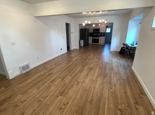545 23rd Street Ogden, UT 84401 - Photo 7 of 28 Spacious interior featuring wood-finish flooring throughout, a modern linear chandelier, and crisp white walls
